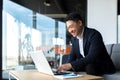 Senior Asian business man working on laptop online, smiling and rejoicing, happy boss business owner working in office Royalty Free Stock Photo