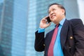 Senior Asian businessman in suit using smart phone Royalty Free Stock Photo