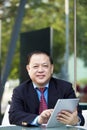 Senior Asian businessman using tablet PC Royalty Free Stock Photo