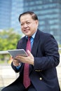 Senior Asian businessman using tablet PC Royalty Free Stock Photo