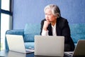 Senior Asian businesswoman sitting at sofa, using laptop computer to work or looking at stock data. Royalty Free Stock Photo