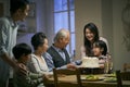Senior asian couple celebrating wedding annversary with three generational family Royalty Free Stock Photo