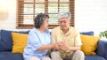 Senior asian couple comforting each other from depressed emotion while sitting on sofa at home living room, old retirement Royalty Free Stock Photo