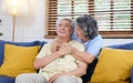 Senior asian couple comforting each other from depressed emotion while sitting on sofa at home living room, old retirement Royalty Free Stock Photo