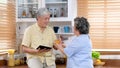 Senior asian couple drinking orange juice while standing by window in kitchen background, Old people retirement and healthy Royalty Free Stock Photo