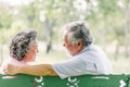 Senior Asian couple enjoying together sitting on bench Royalty Free Stock Photo