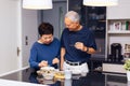 Senior Asian couple grandparents cooking together while woman is feeding food to man at the kitchen. Long lasting relationship Royalty Free Stock Photo