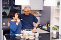 Senior Asian couple grandparents cooking together while woman is feeding food to man at the kitchen. Long lasting relationship