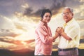 Senior couple holding hands for love and togetherness concept with golden sky nature background Royalty Free Stock Photo