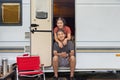 Senior asian couple joyful and relax sitting in front of caravan home on vacation