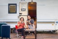 Senior asian couple joyful and relax sitting in front of caravan home on vacation