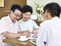 Senior asian couple signing a contract