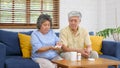 Senior asian couple take pill medicine for elderly health care while sitting on sofa, Retirement couple take vitamin pill, Senior Royalty Free Stock Photo