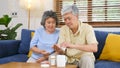 Senior asian couple take pill medicine for elderly healthy lifestyle while sitting on sofa at home living room, retirement people Royalty Free Stock Photo