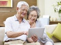 Senior asian couple using a tablet computer together Royalty Free Stock Photo