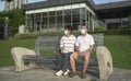 Senior Asian couple wearing face mask sitting on a bench in a park Royalty Free Stock Photo