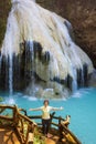 Senior asian female tourist relaxing at waterfall on tropical forest trail in the outdoor. Royalty Free Stock Photo