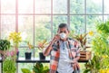 Senior Asian man drinking coffee and relaxing alone in his houseplant room while in quarantine at home Royalty Free Stock Photo