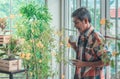Senior Asian man drinking coffee and relaxing alone in his houseplant room while in quarantine at home Royalty Free Stock Photo