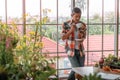 Senior Asian man drinking coffee and relaxing alone in his houseplant room while in quarantine at home Royalty Free Stock Photo