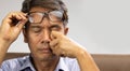 Senior asian man has eyestrain and fatigue Royalty Free Stock Photo