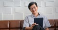 Senior Asian man playing tablet and video call on sofa in living room at home  Portrait of Asian elderly man is Relaxing and Royalty Free Stock Photo