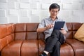 Senior Asian man playing tablet and video call on sofa in living room at home  Portrait of Asian elderly man is Relaxing and Royalty Free Stock Photo