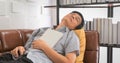 Senior Asian man reading book and sleep on sofa in living room at home ,Portrait of Asian elderly man is Relaxing and Happiness Royalty Free Stock Photo