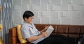 Senior Asian man reading book on sofa in living room at home ,Portrait of Asian elderly man is Relaxing and Happiness With Read a Royalty Free Stock Photo