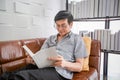 Senior Asian man reading book on sofa in living room at home ,Portrait of Asian elderly man is Relaxing and Happiness With Read a Royalty Free Stock Photo