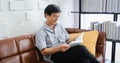 Senior Asian man reading book on sofa in living room at home ,Portrait of Asian elderly man is Relaxing and Happiness With Read a Royalty Free Stock Photo