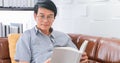 Senior Asian man reading book on sofa in living room at home ,Portrait of Asian elderly man is Relaxing and Happiness With Read a Royalty Free Stock Photo