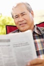 Senior Asian man reading outdoors