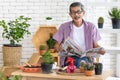 A senior Asian man sitting and drink coffee and reading the newspaper with happiness. Idea for relaxing and slowly life of older Royalty Free Stock Photo