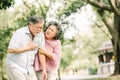 Senior Asian man suffering from heart attack while his wife giving support Royalty Free Stock Photo