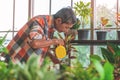 Senior Asian man watering houseplant in his home gardening small business plant workshop Royalty Free Stock Photo