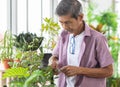 A senior Asian man working in a planting hobby room with happiness. Idea for green lover who plants tree and botany in corner of Royalty Free Stock Photo