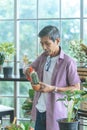 Senior retired man is spraying water on cactus pot welness hobby lifestyle