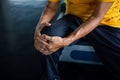 Senior asian sport man injury knee pain  sitting on treadmill in fitness gym . aged  suffering from Arthritis elder male Royalty Free Stock Photo