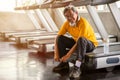 Senior asian sport man tying shoelaces on treadmill in fitness gym ready walking with headphone and water bottle . elder male Royalty Free Stock Photo