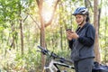 Senior asian woman bicycle in the park, With using smart phone Royalty Free Stock Photo