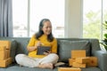 Senior Asian woman doing online shopping at home with boxes and laptop Royalty Free Stock Photo