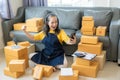 Senior Asian woman doing online shopping at home with boxes and laptop Royalty Free Stock Photo