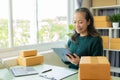 Senior Asian woman doing online shopping at home with boxes and laptop Royalty Free Stock Photo