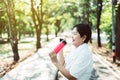 Senior asian woman drinking water after break workout at public park in the morning,Healthy elderly women concept Royalty Free Stock Photo