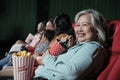 Senior Asian woman enjoy watching funny cinema in movie theaters.