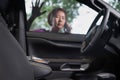 Senior asian woman forgot her key inside locked car