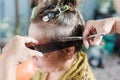 Senior Asian woman haircut, using scissors and a comb