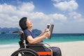 Senior asian woman laughing while reading magazine on beach Royalty Free Stock Photo