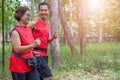 Senior asian woman with man or personal trainer jogging running in the park